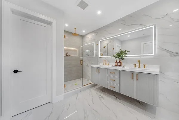 a bathroom with a double vanity sink mirror and shower