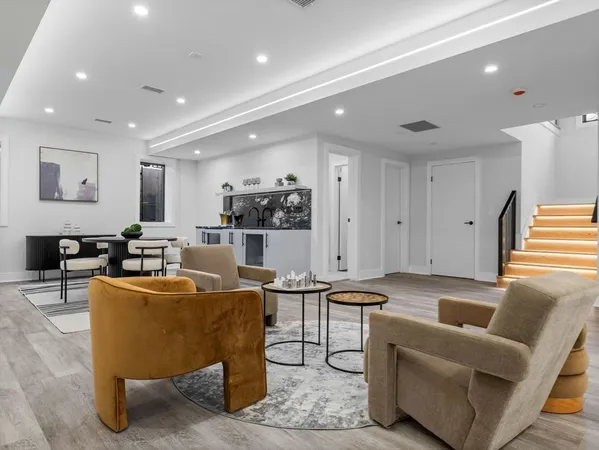 a living room with furniture a flat screen tv and kitchen view