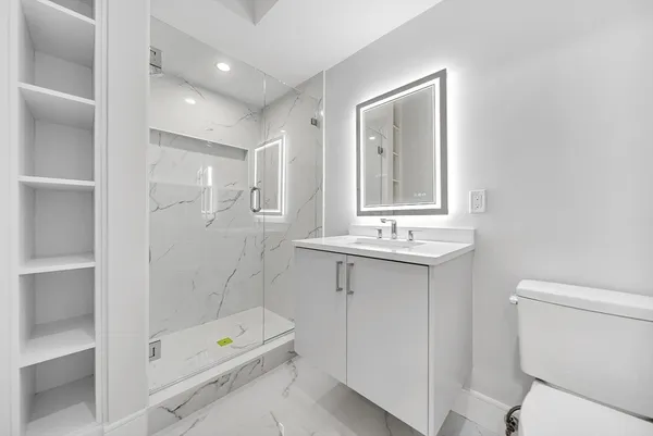 a bathroom with a sink a toilet and shower