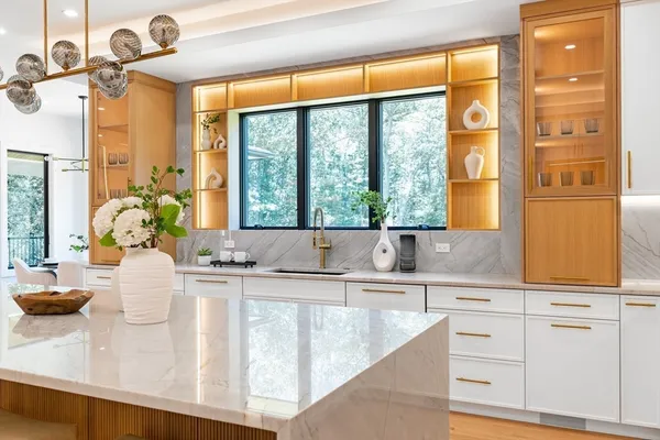 a kitchen with kitchen island a large window in it