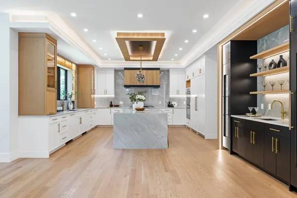 a large kitchen with stainless steel appliances kitchen island a large counter top and a stove top oven