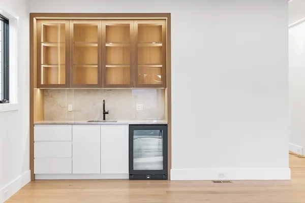 a view of an empty room with wooden floor and cabinets