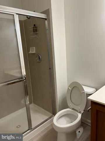 a white toilet sitting next to a shower
