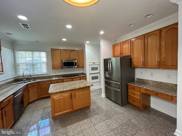 a kitchen with stainless steel appliances granite countertop a refrigerator stove and sink
