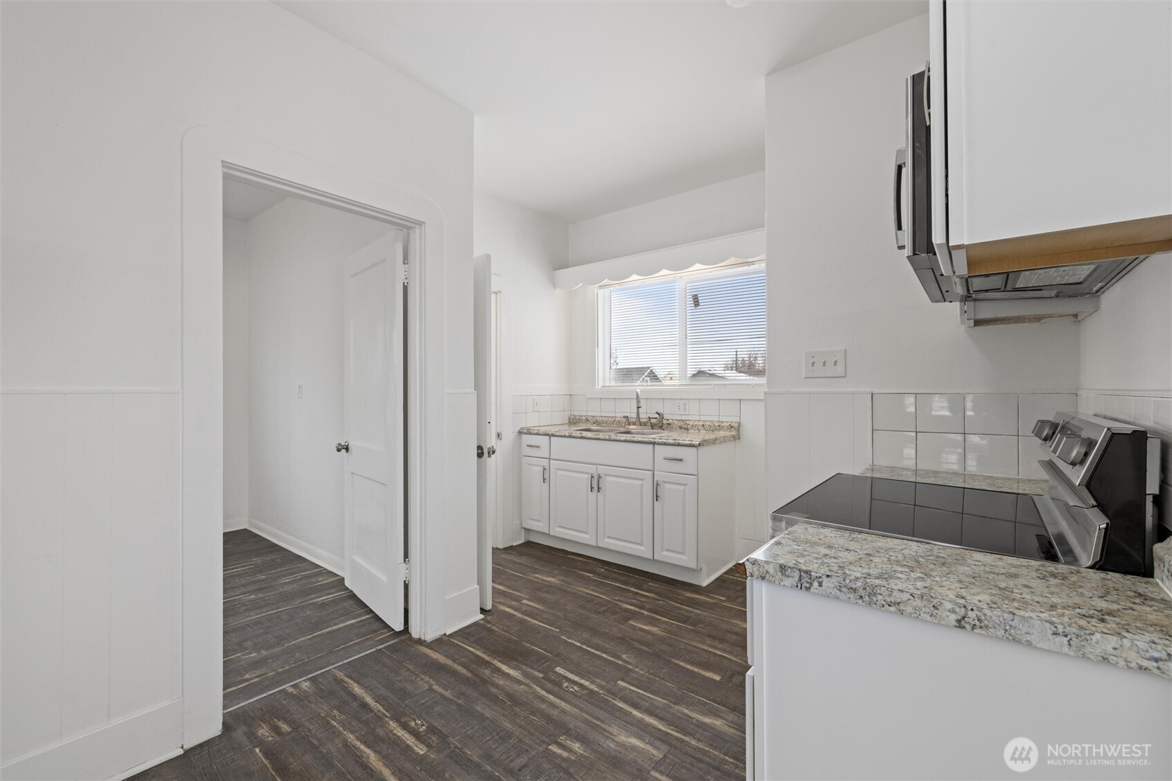 902 Emma Street Walla Walla, WA 99362 - Photo 8 of 29 a kitchen with a sink dishwasher a stove and white cabinets with wooden floor