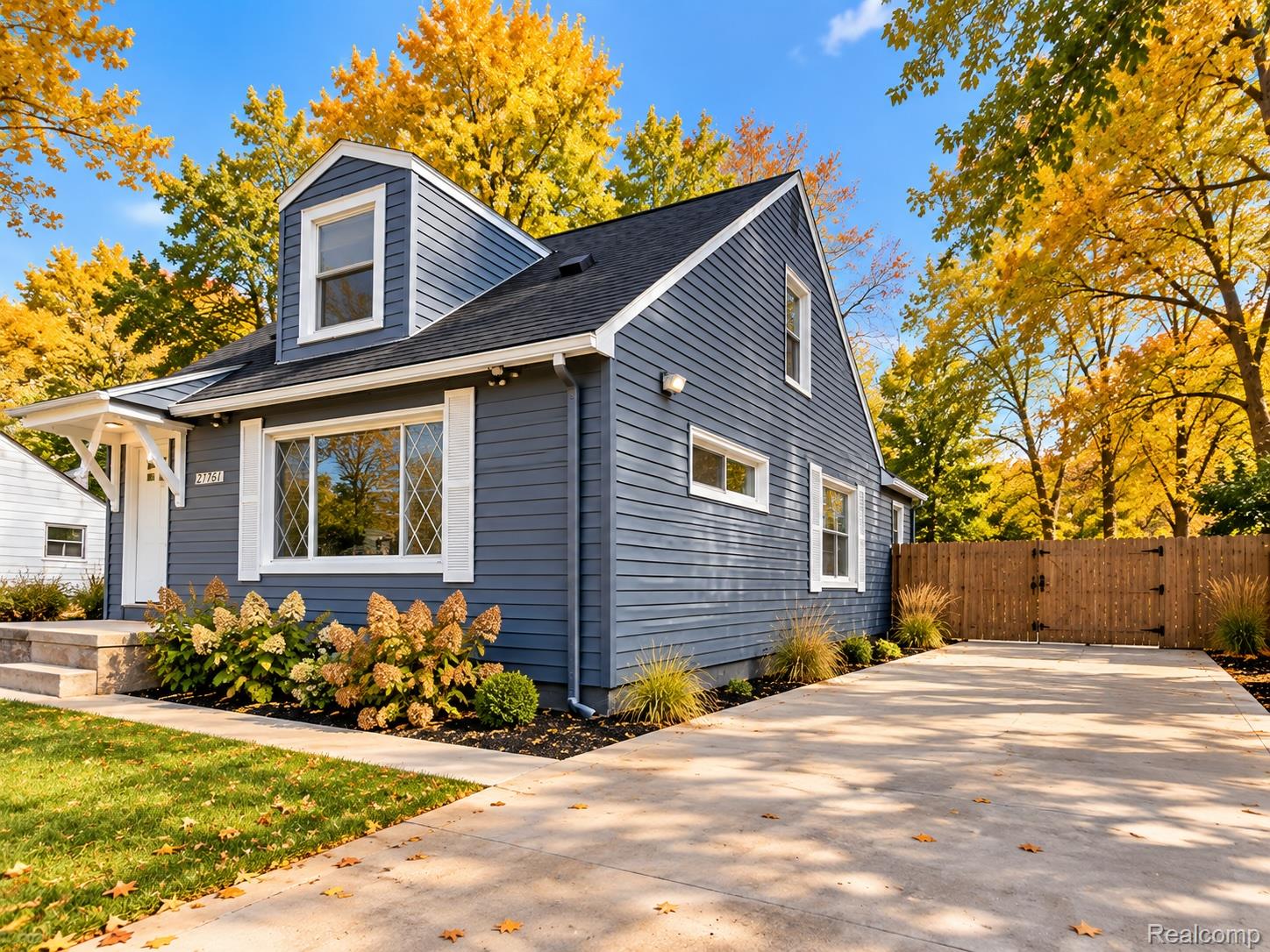 21761 Middlebelt Road Farmington, MI 48336 - Photo 21 of 21 Blue-gray siding exterior featuring a dormer window, white window trim, and a white portico over the entry