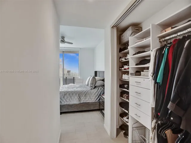 a view of walk in closet with clothes and shoes