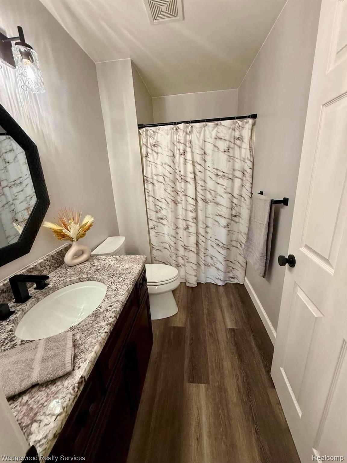 492 Harvard Drive, Unit 84 Romeo, MI 48065 - Photo 16 of 30 Bathroom featuring a dark wood-finish vanity with granite-style countertop, white oval sink, and matte black faucet