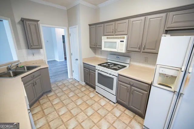 a kitchen with granite countertop a sink stove and refrigerator