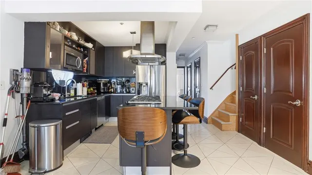 a kitchen with stainless steel appliances granite countertop a stove refrigerator and cabinets