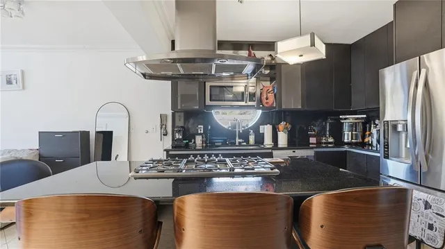a kitchen with stainless steel appliances granite countertop a stove and a refrigerator