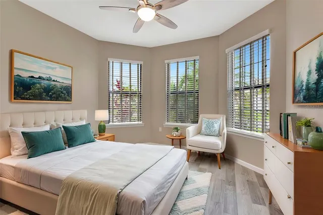 a view of an empty room with wooden floor and windows