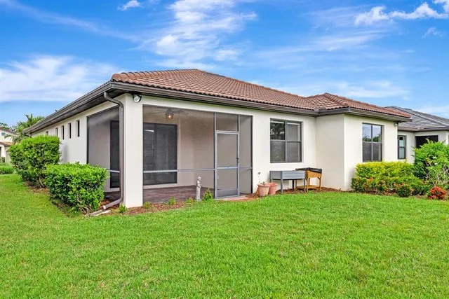 a view of a house with brick walls and a yard with plants
