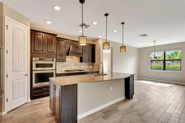 a kitchen with kitchen island a counter top stainless steel appliances and cabinets