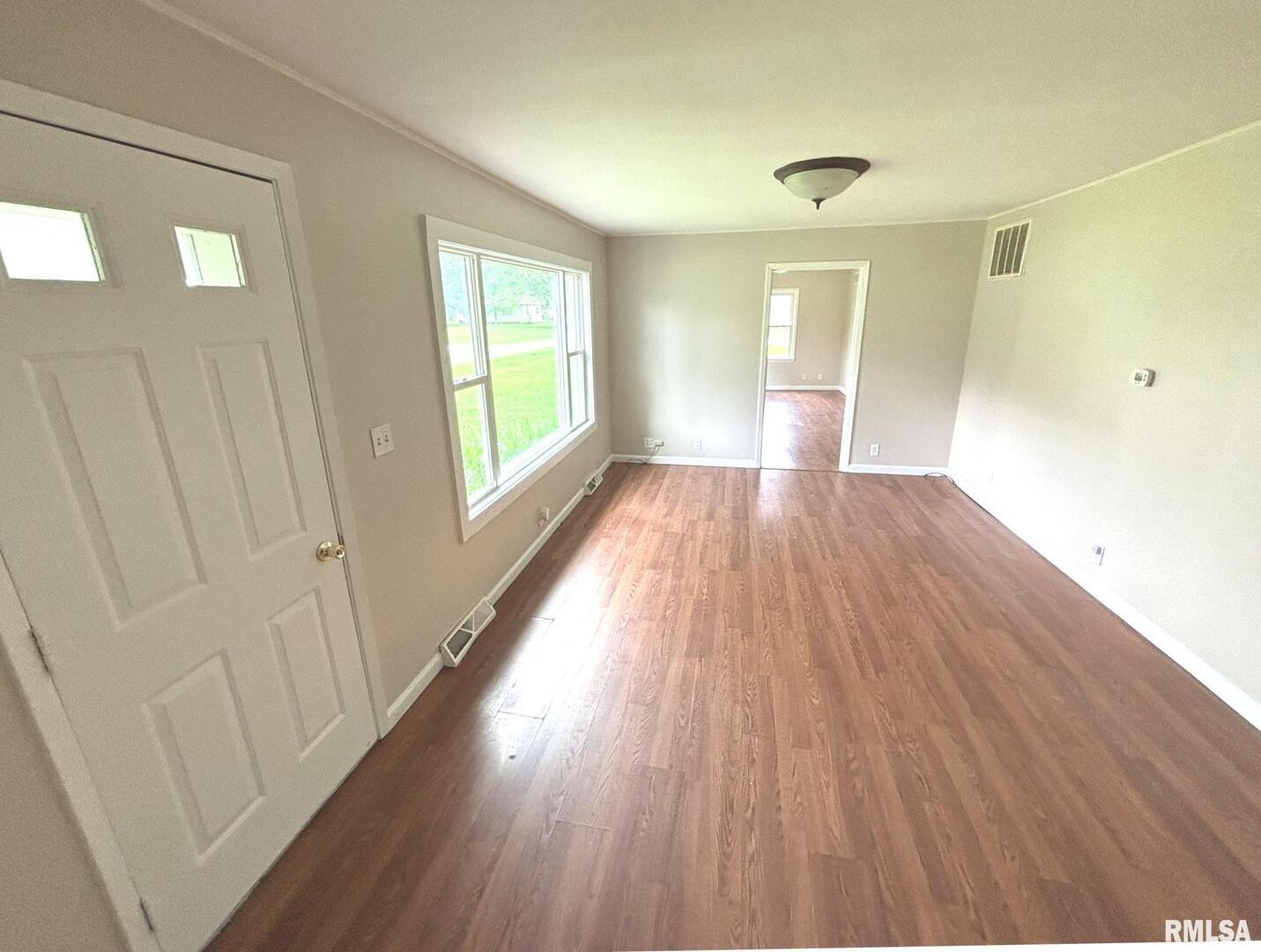 145 Hickory Grove Lane Salem, IL 62881 - Photo 3 of 20 a view of an empty room with wooden floor and a window