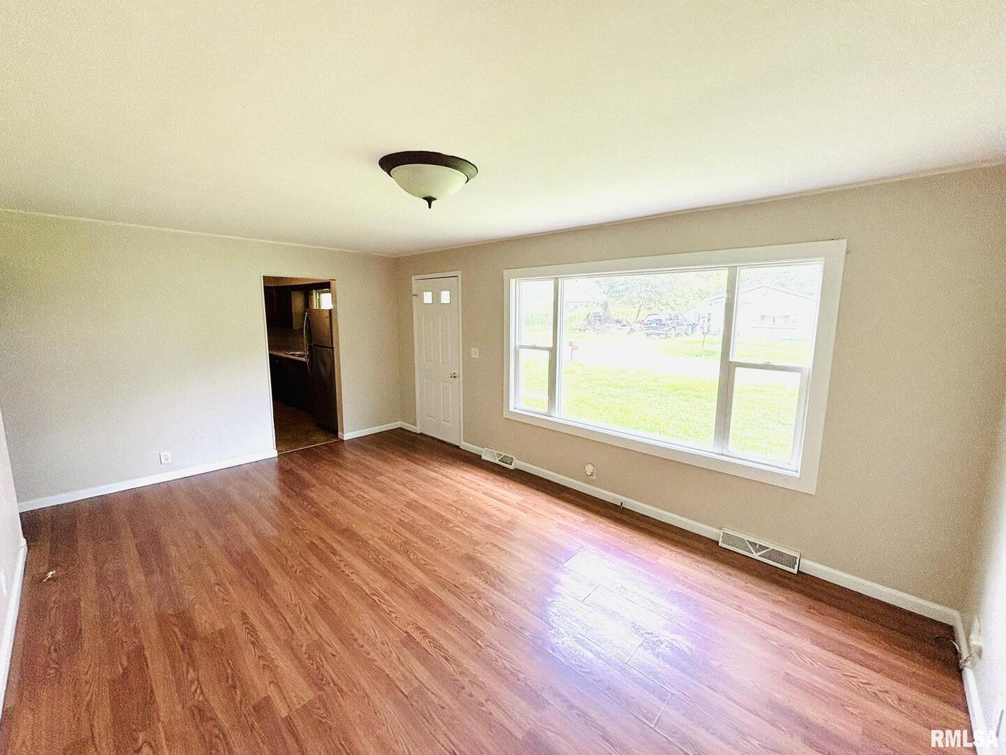 145 Hickory Grove Lane Salem, IL 62881 - Photo 4 of 20 an empty room with wooden floor and windows