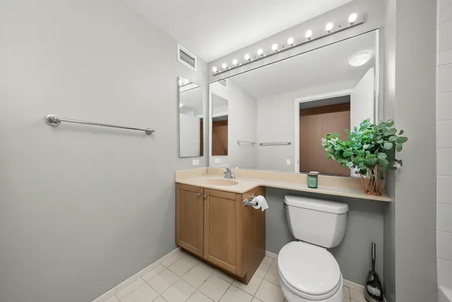 a bathroom with a sink a toilet a mirror and shower