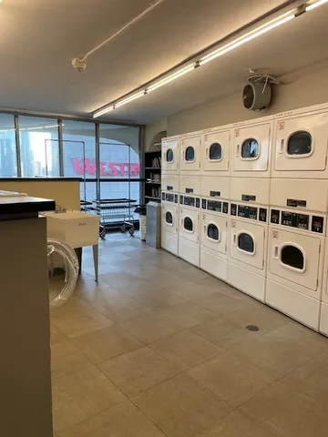 a white kitchen with stainless steel appliances a stove a sink and a refrigerator
