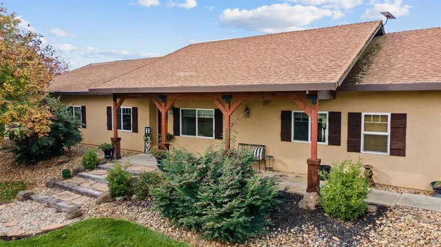 a view of a house with a yard and potted plants