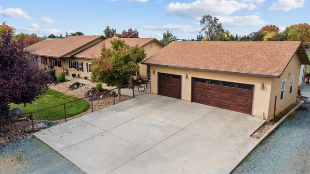 an aerial view of a house with swimming pool and outdoor seating