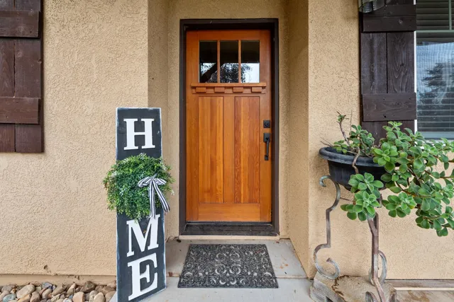 a view of a house with wooden deck next to a yard