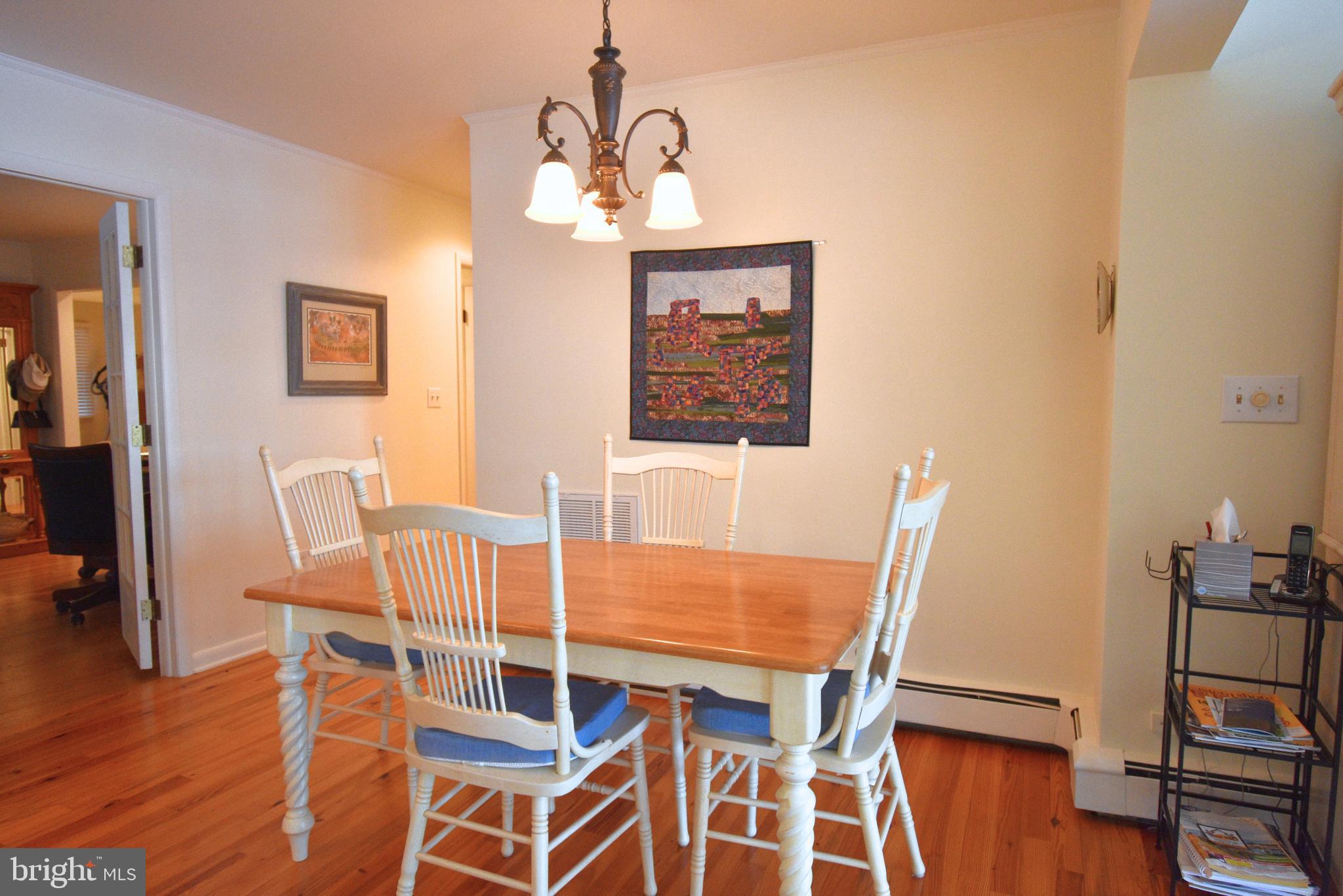 7361 Solitude Road St. Michaels, MD 21663 - Photo 18 of 23 a view of a dining room with furniture wooden floor and a chandelier