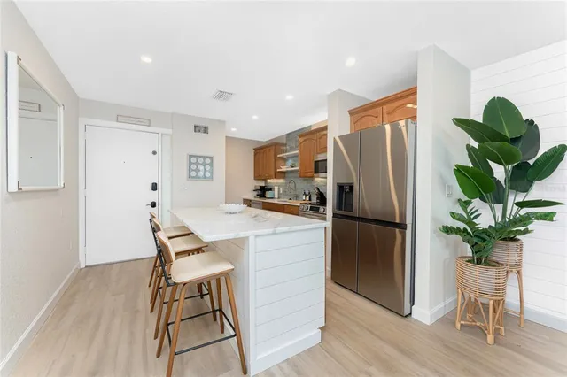 a kitchen with stainless steel appliances a refrigerator a table and chairs