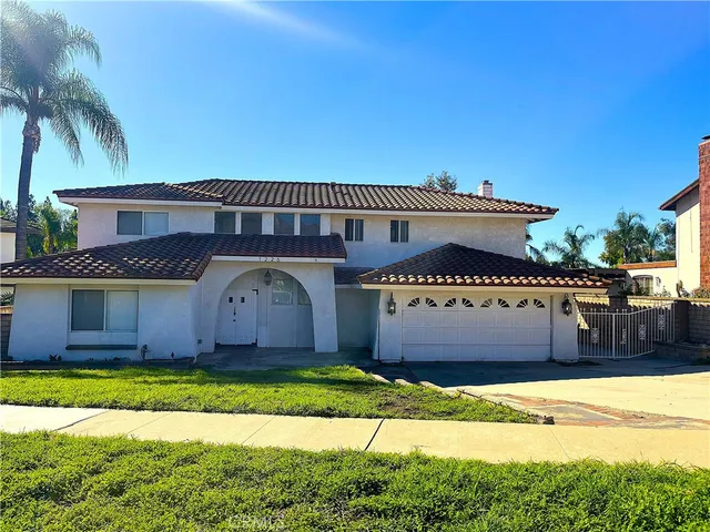a front view of a house with a garden and yard