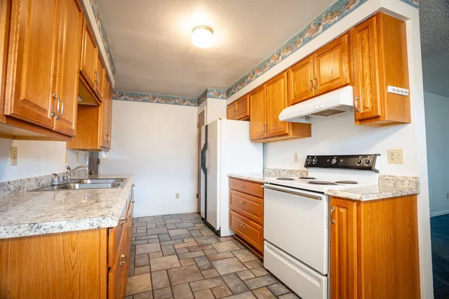 a kitchen with granite countertop cabinets and window