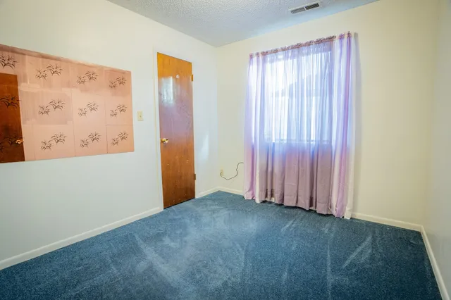 an empty room with windows and television