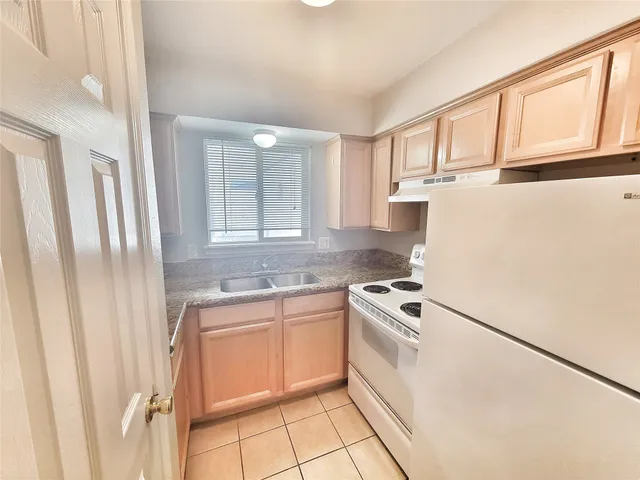 a kitchen with a stove a sink and a refrigerator