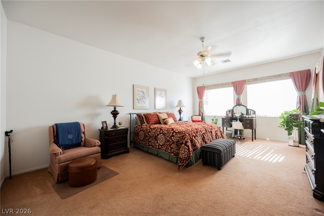 5494 Pine Ranch Street Las Vegas, NV 89113 - Photo 48 of 54 A spacious bedroom offers comfort and a well-lit vanity space, creating a peaceful retreat.