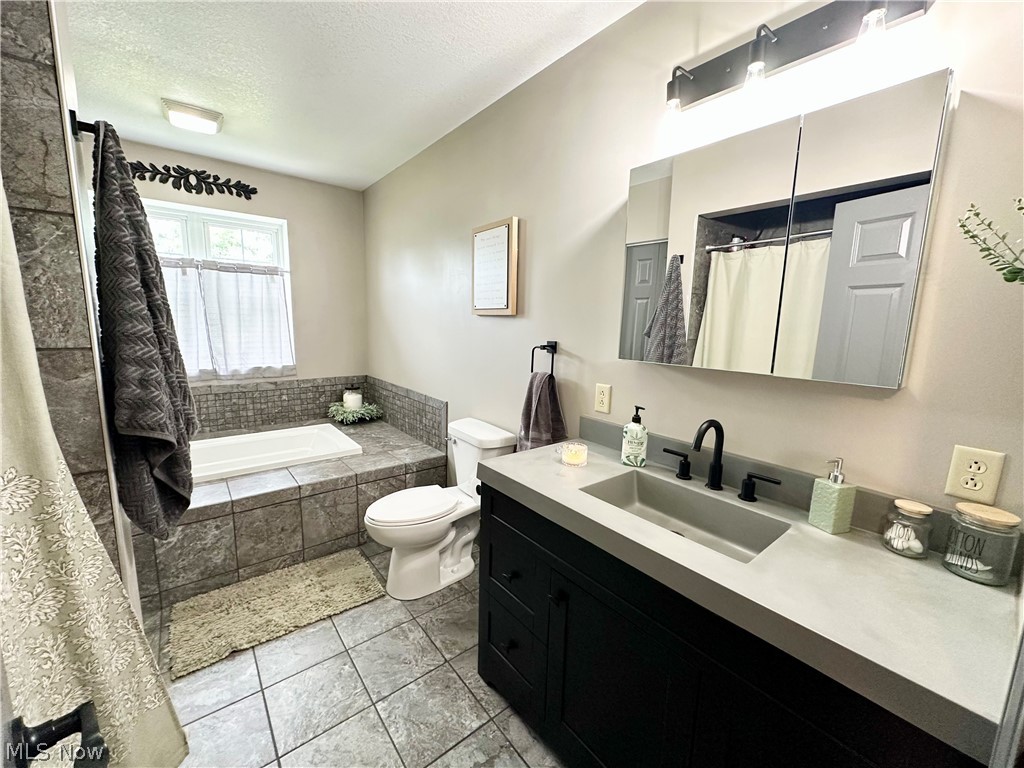 148 Rural Lane Chester, WV 26034 - Photo 20 of 32 Bathroom featuring large soaking tub, sink vanity, and ceramic tile flooring