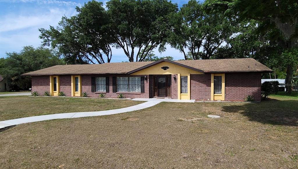 406 Wright Street Inverness, FL 34452 - Photo 2 of 38 a front view of a house with a garden