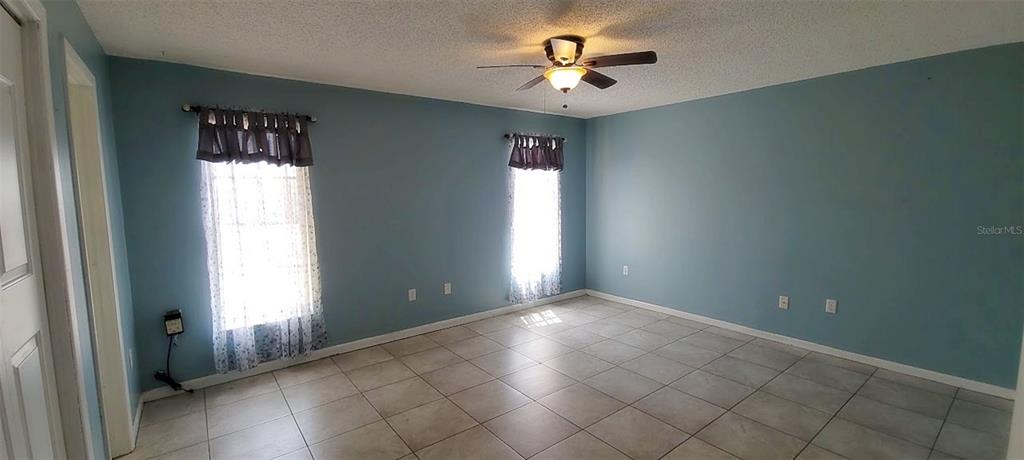 406 Wright Street Inverness, FL 34452 - Photo 22 of 38 an empty room with windows and chandelier fan