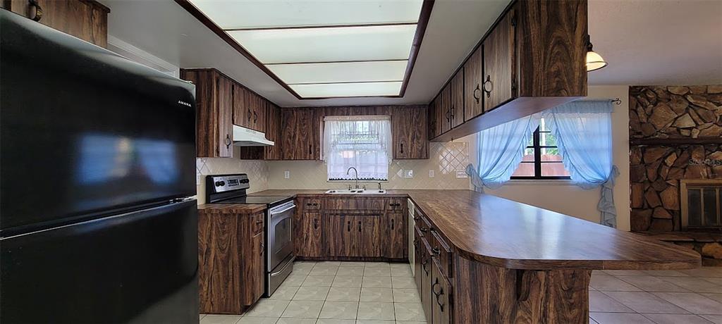 406 Wright Street Inverness, FL 34452 - Photo 8 of 38 a kitchen with stainless steel appliances a sink dishwasher a stove top oven a refrigerator and cabinets