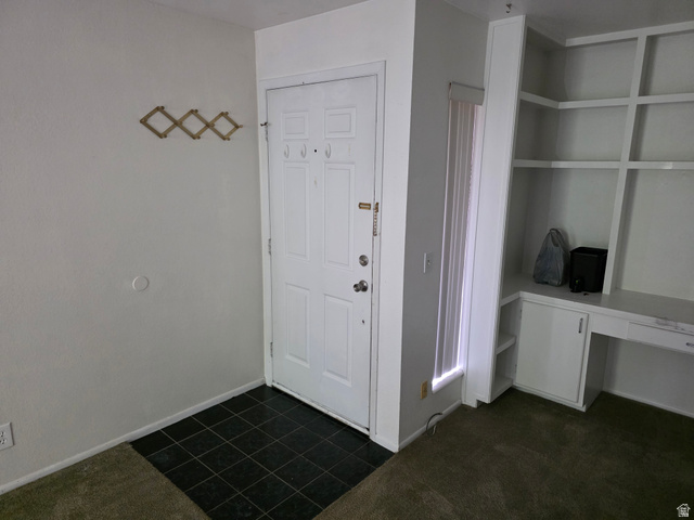 6852 Countrywoods Circle, Unit 5D Midvale, UT 84047 - Photo 6 of 50 Entryway featuring a white paneled door, dark tile flooring, and an integrated built-in desk with shelving