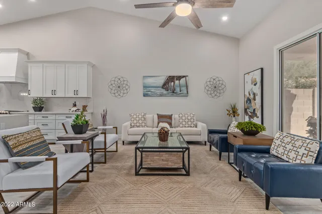 a living room with furniture kitchen view and a wooden floor