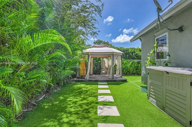 a view of a patio with a table and chairs under an umbrella