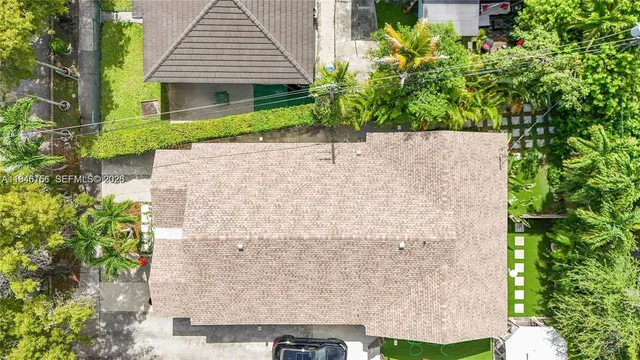 front view of a house with a yard and potted plants