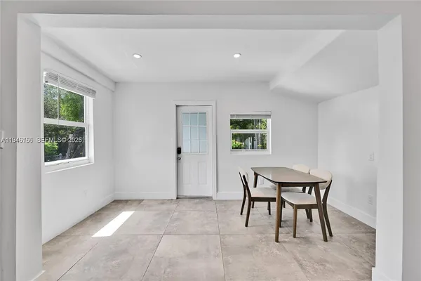 a view of a room that has a window and a table in it