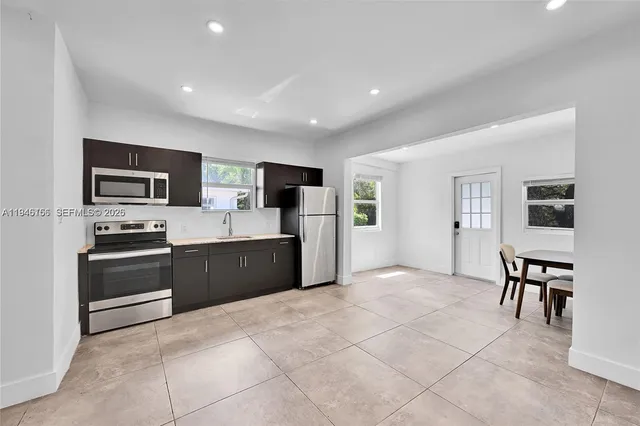 a large kitchen with cabinets wooden floor and stainless steel appliances