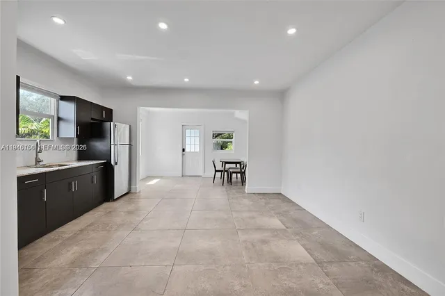 a large white kitchen with lots of counter top space and stainless steel appliances