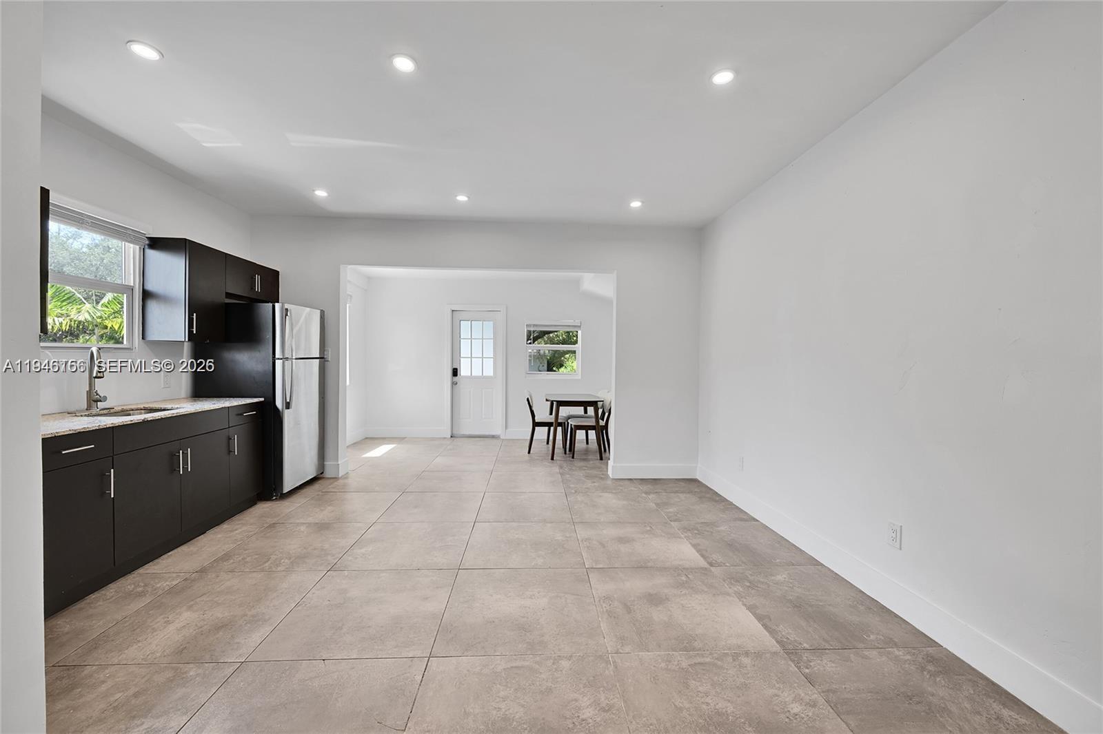 21 Northeast 48th Street, Unit 21 Miami, FL 33137 - Photo 6 of 32 a large white kitchen with lots of counter top space and stainless steel appliances