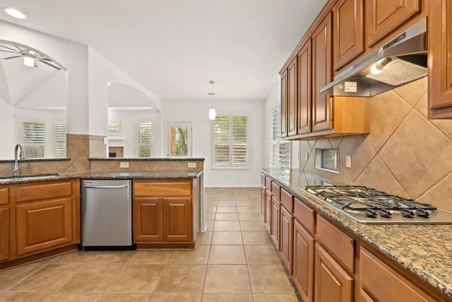 a kitchen with stainless steel appliances granite countertop a stove and a sink