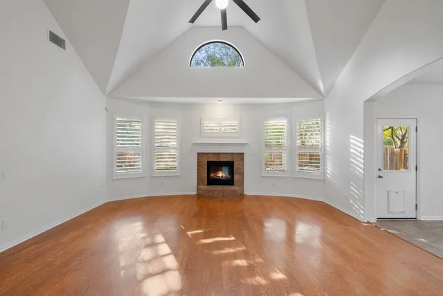 a view of an empty room with a window and fireplace