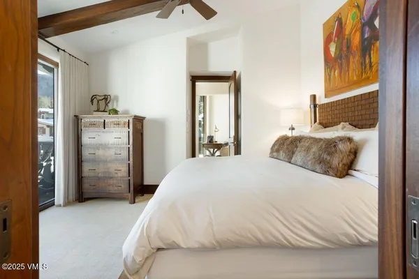 a spacious bedroom with a bed and painting on the wall