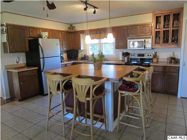 581 Madrid Road Waynesboro, VA 22980 - Photo 3 of 21 a kitchen with stainless steel appliances granite countertop a stove a refrigerator a sink a dining table and chairs
