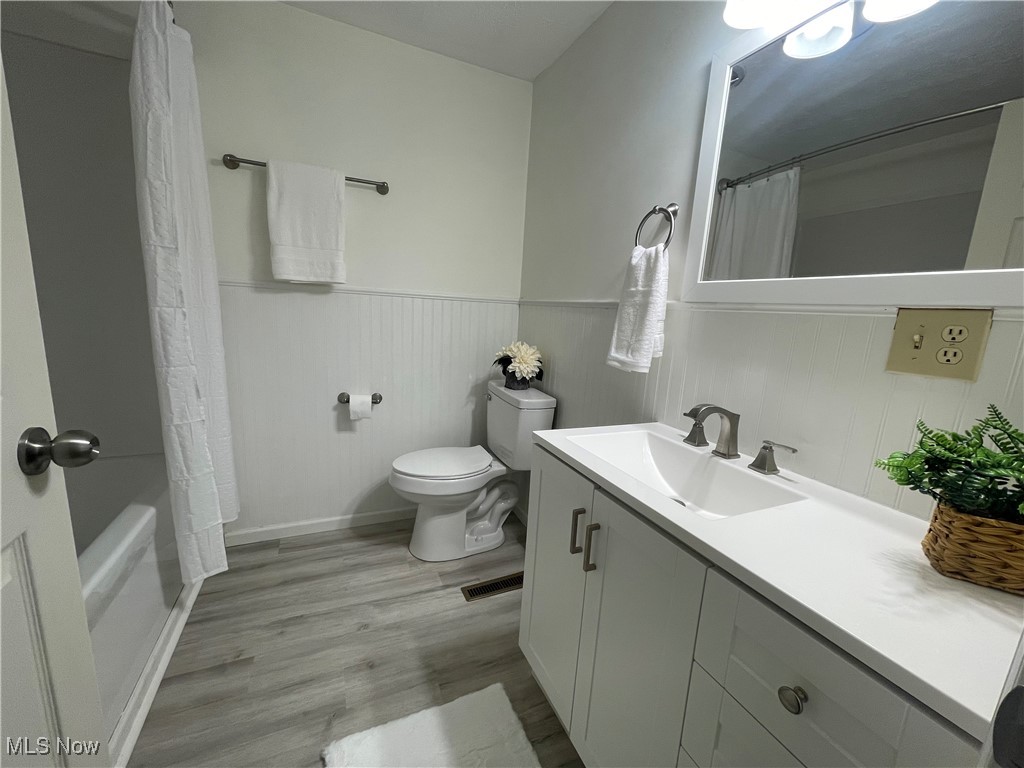1984 Hebron Road St. Marys, WV 26170 - Photo 17 of 33 Bathroom with wainscoting, toilet, wood finished floors, and vanity