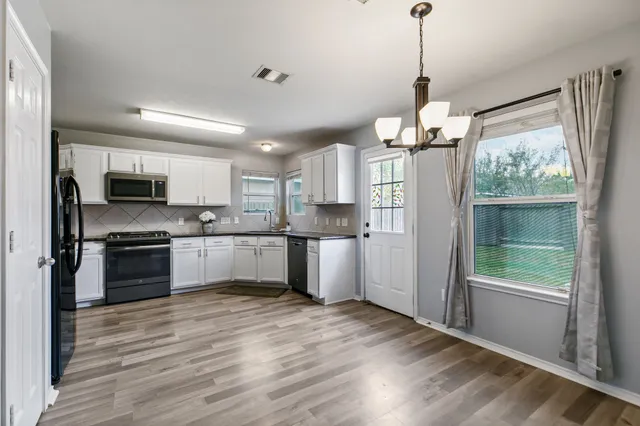a large kitchen with granite countertop a large window and stainless steel appliances